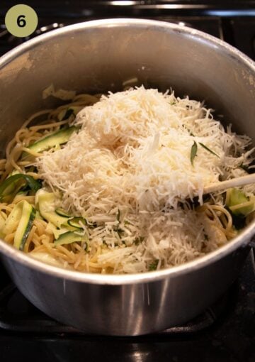 adding grated goat cheese gouda to a pot with spaghetti.