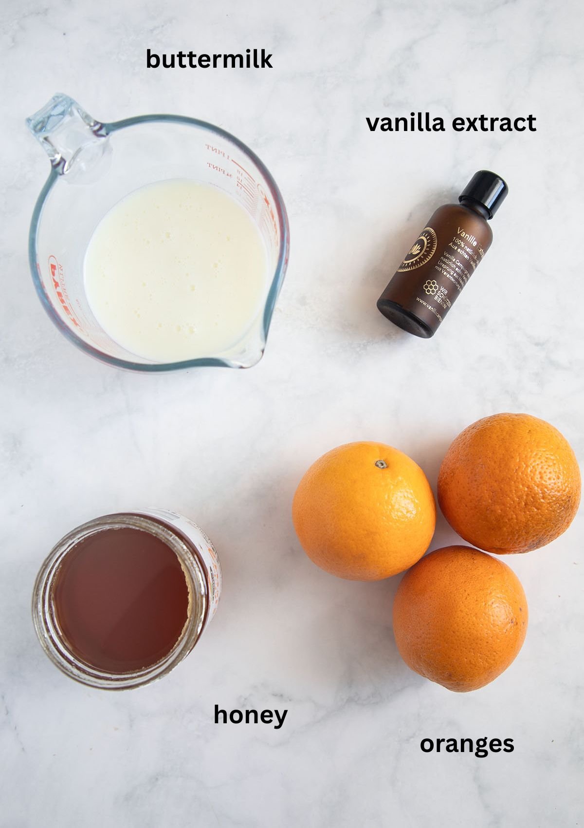 labeled ingredients for making pospsicles with fresh oranges, buttermilk, vanilla extract and honey.