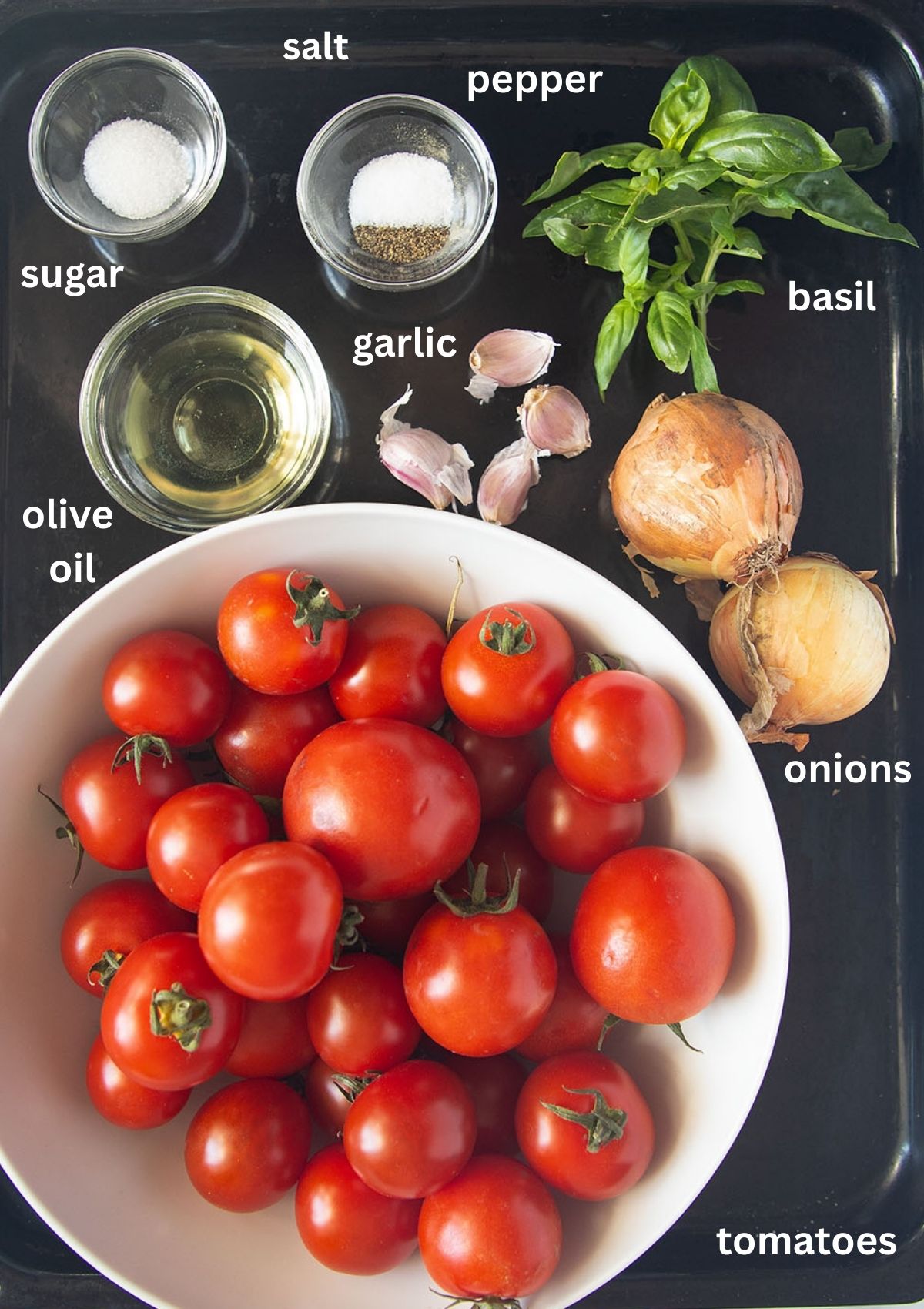 labeled ingredients for making pasta sauce with roasted tomatoes, onions, garlic, olive oil, and basil.