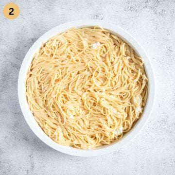 spaghetti pizza crust in a baking dish before baking.