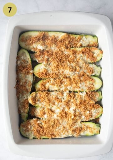 zucchini boats with feta and breadcrumbs in a baking dish before baking.