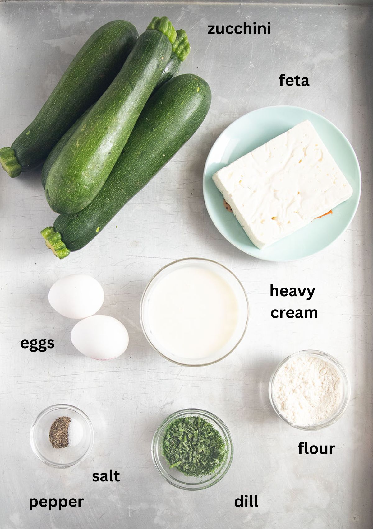 labeled ingredients for making zucchini boats stuffed with feta, cream, eggs, dull and seasoning.