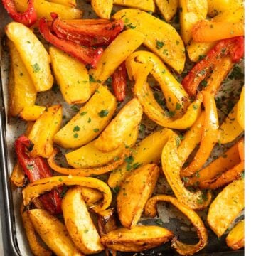 roasted potatoes and peppers on a sheet pan.