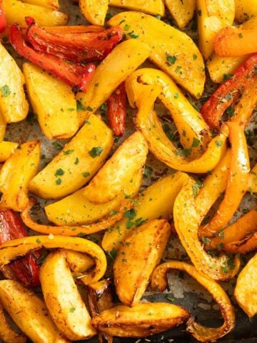 roasted potatoes and peppers on a sheet pan.