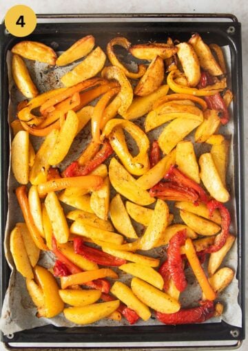 roasted peppers and potatoes on a baking sheet lined with parchment paper.