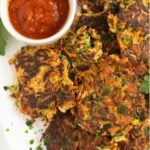 zucchini and sweet potato fritters and a bowl of chili dip.