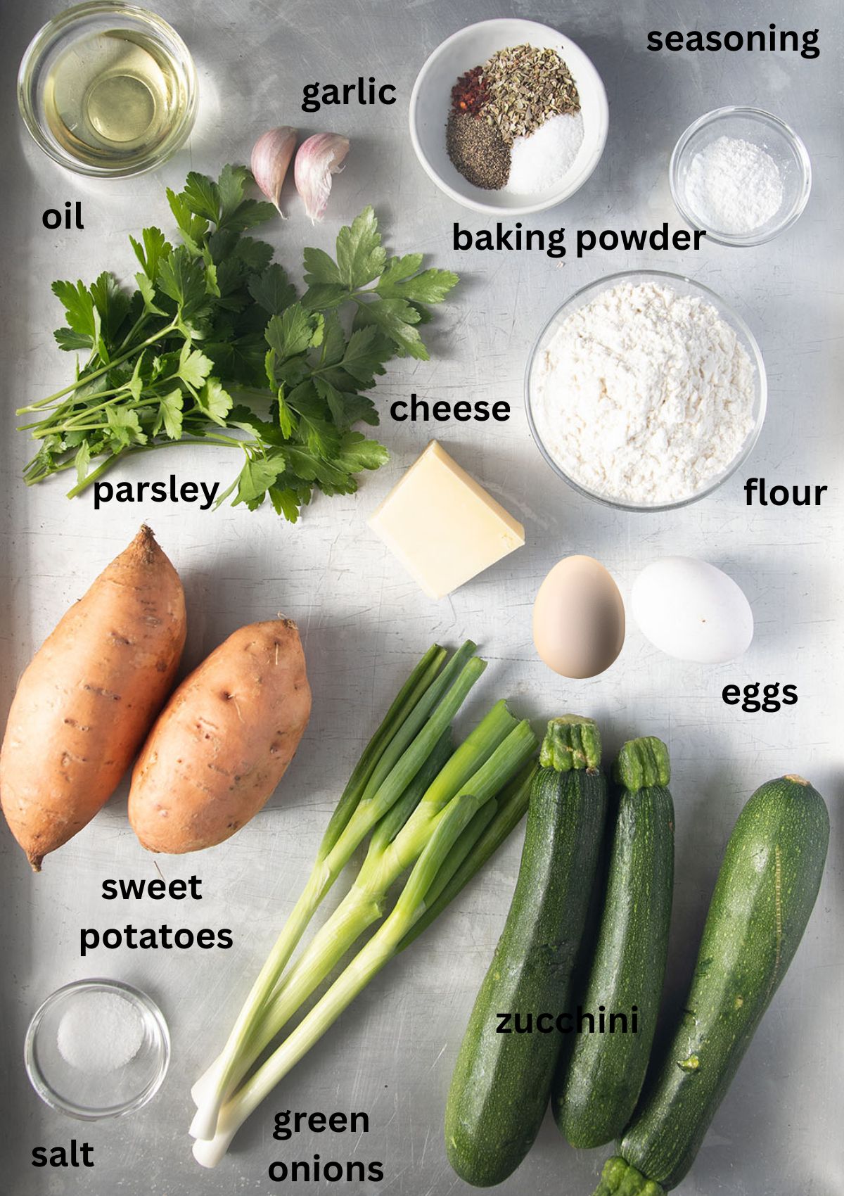 labeled ingredients for making fritters with zucchini, sweet potatoes, eggs, flour, seasoning, and green onions.