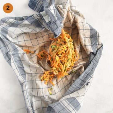 squeezed out zucchini and sweet potatoes for making fritters in a kitchen towel.