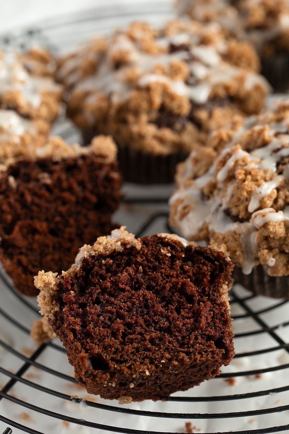 pumpkin crumble muffins, one cut in the middle showing the chocolatey crumb.