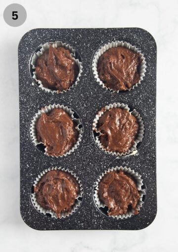 unbaked muffin batter with pumpkin a 6-cup muffin pan.