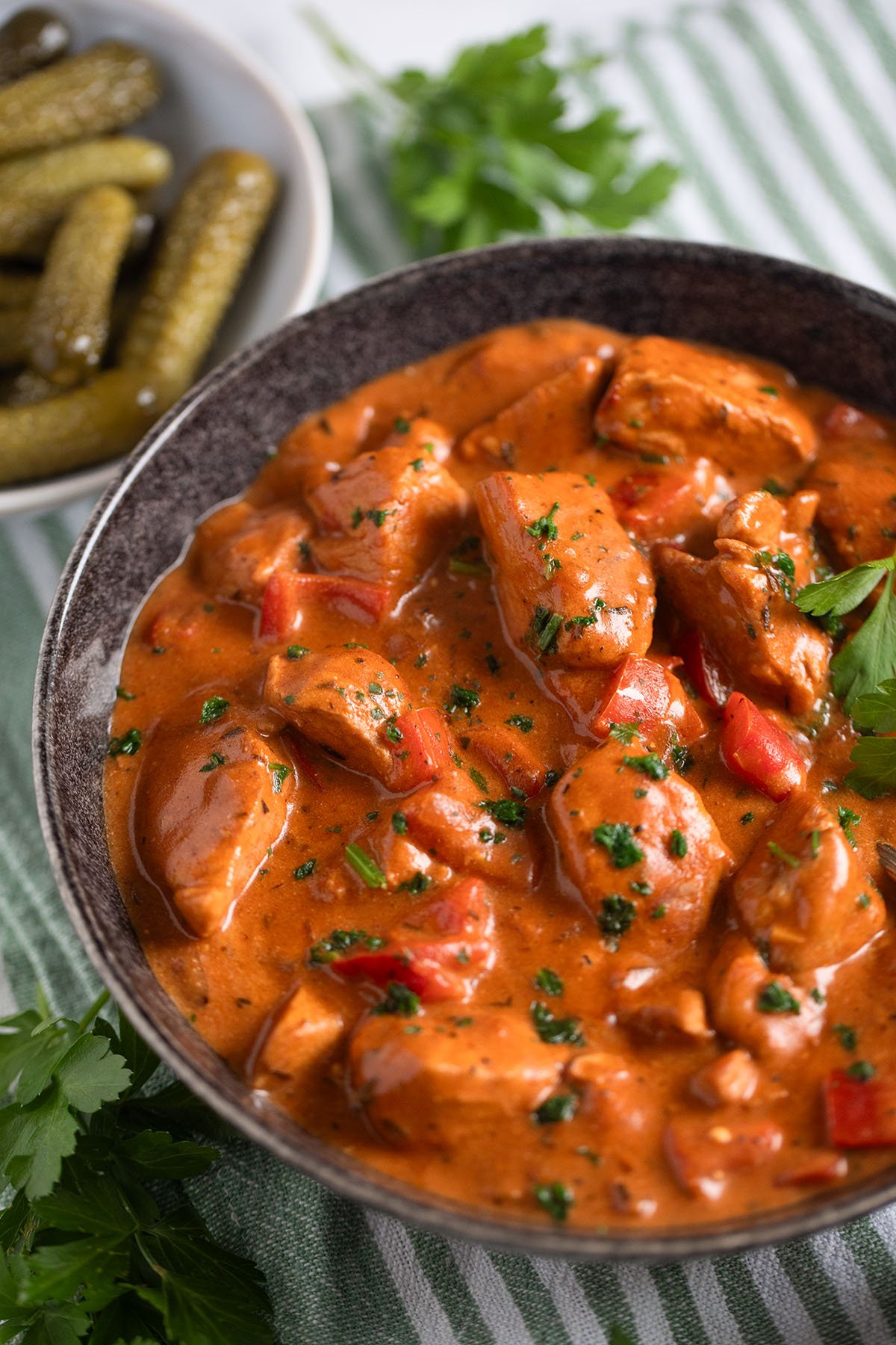 turkey paprika in creamy sauce sprinkled with parsley in a bowl.