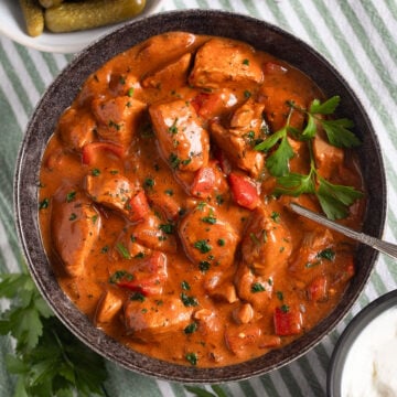 creamy turkey paprika with peppers in a large bowl with a spoon in it.