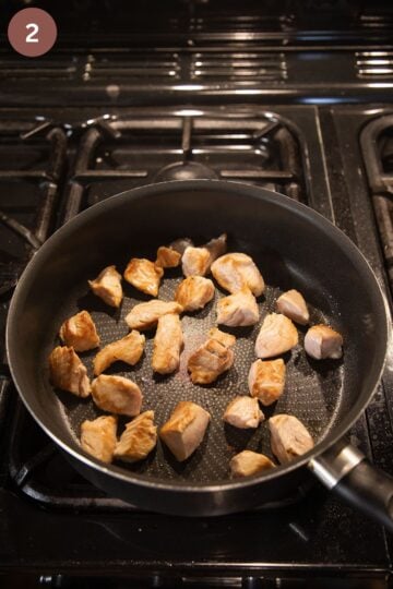 searing turkey breast cubes in a large pan.
