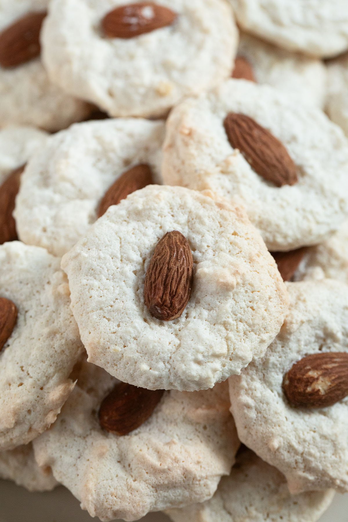 many almond macaroons with a whole almond in the middle close up.