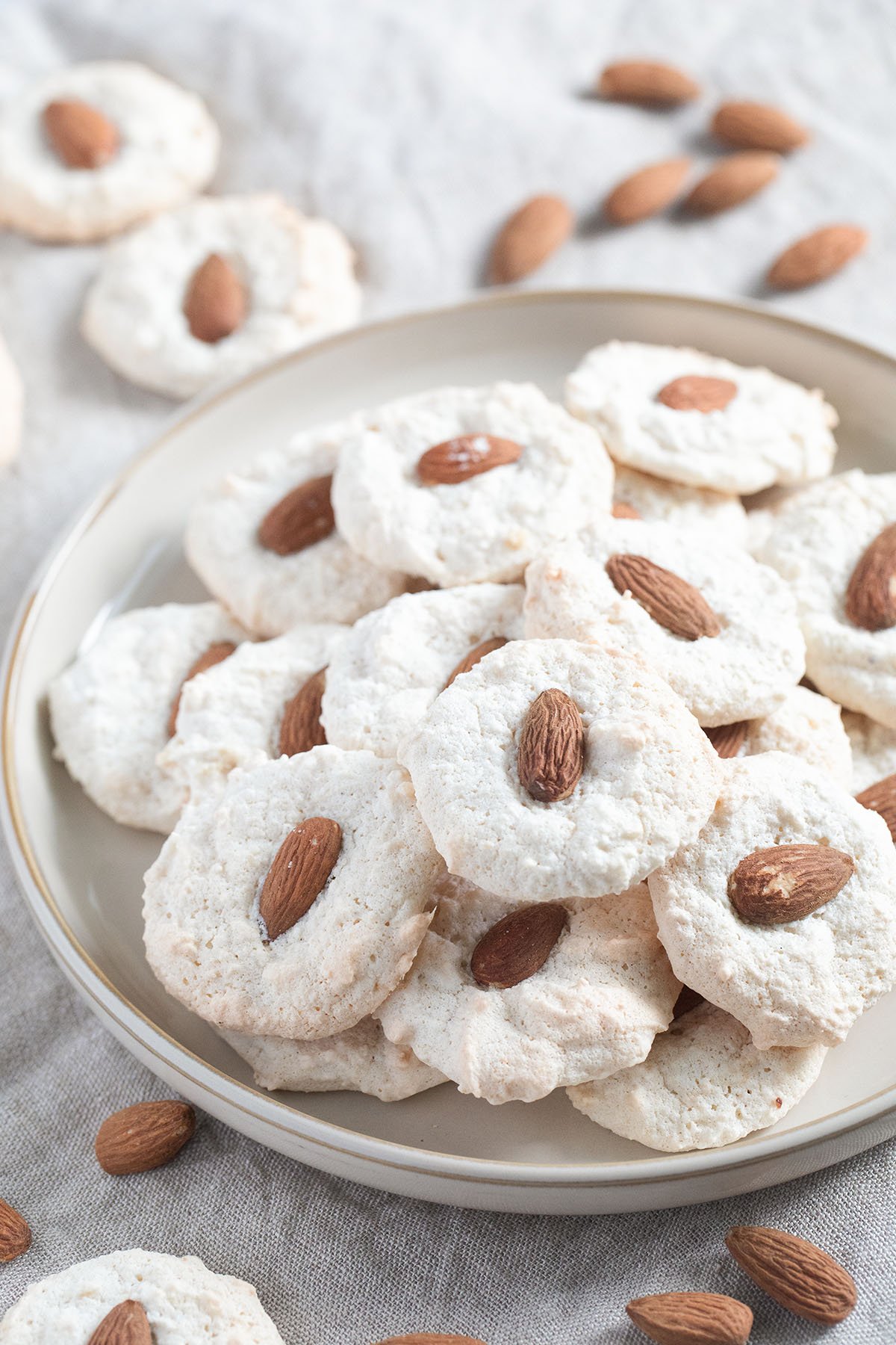 german almond macaroons with whole almonds on top on a plate.
