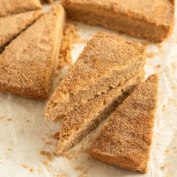 cinnamon shortbread cut into triangles on parchment paper.