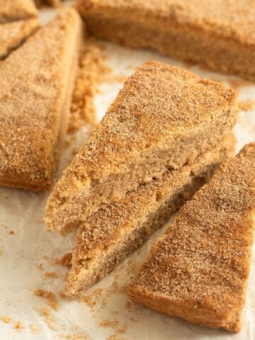 cinnamon shortbread cut into triangles on parchment paper.