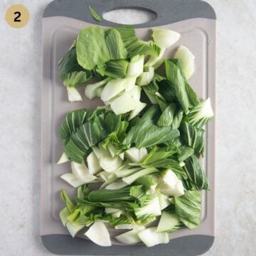 pak choi cut at an angle on a cutting board.