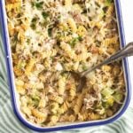 broccoli and tuna pasta bake in a casserole dish with a spoon in it.
