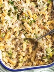 broccoli and tuna pasta bake in a casserole dish with a spoon in it.
