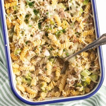 broccoli and tuna pasta bake in a casserole dish with a spoon in it.