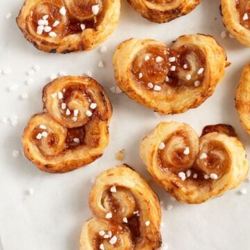 many puff pastry hearts with jam and sprinkled with pearl sugar.