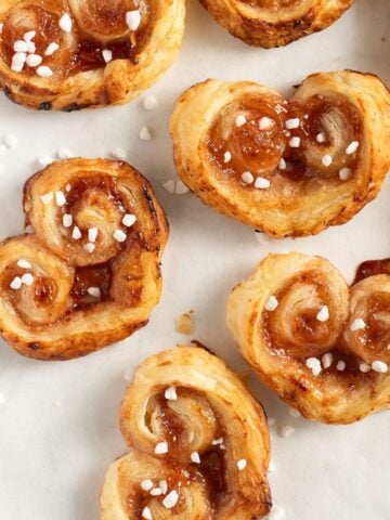 many puff pastry hearts with jam and sprinkled with pearl sugar.