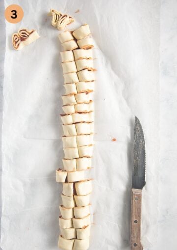 a long log of puff pastry filled with jam and a small serrated knife.