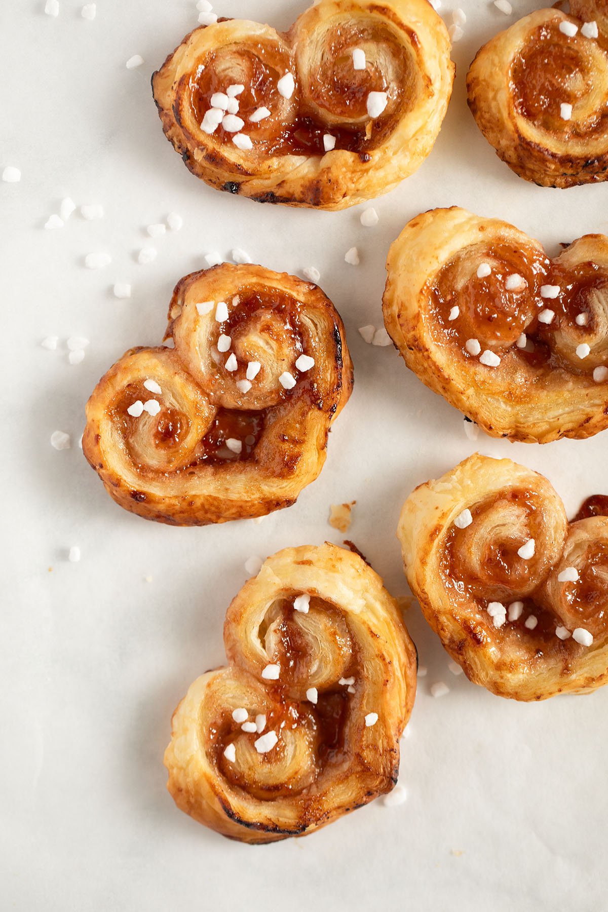 puff pastry hearts with jam on the table.