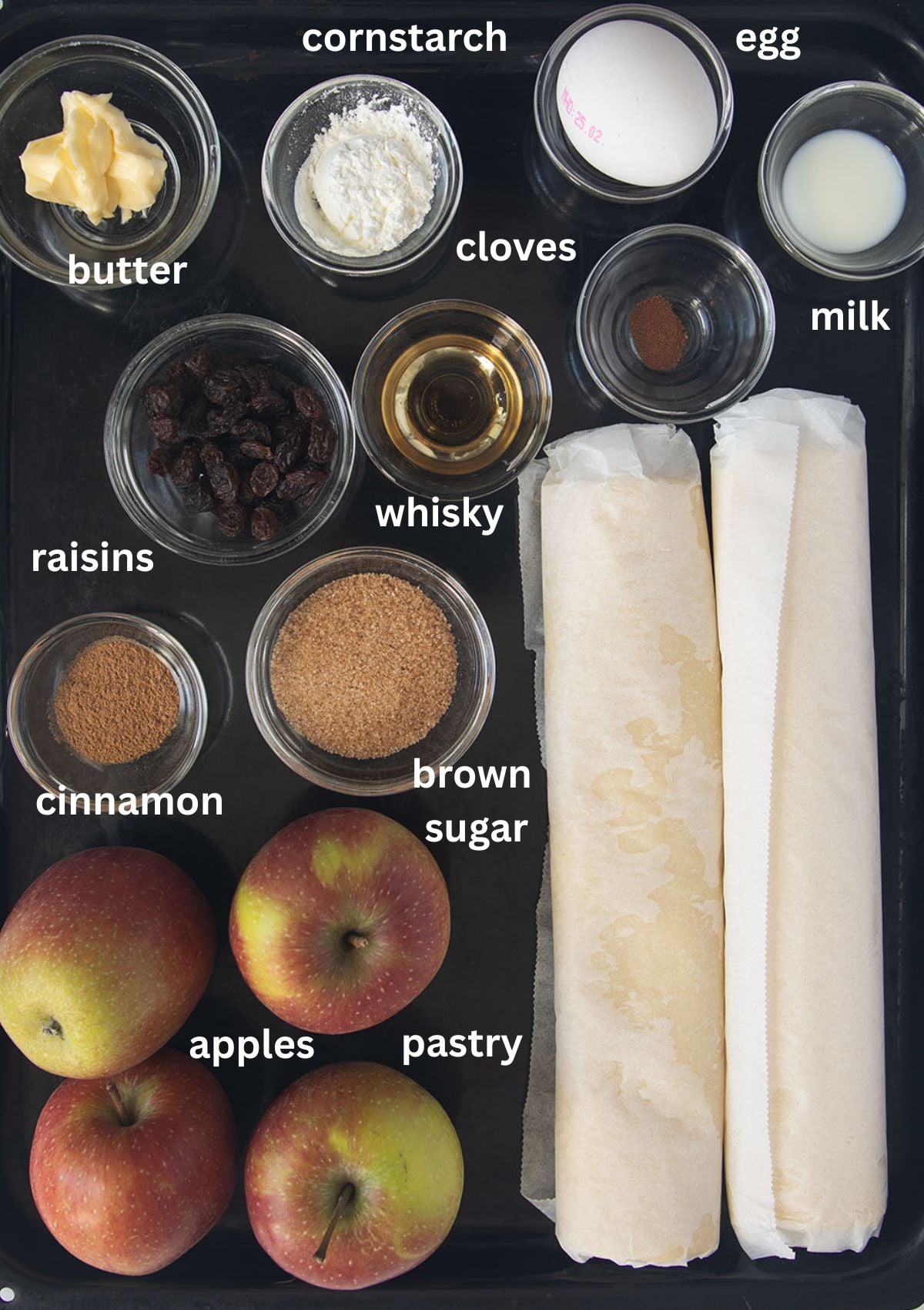 labeled ingredients for making irish pie with apples, bought pie crust, spices, brown sugar and whikey.