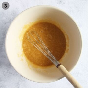 whisking brown sugar and vanilla into melted butter and egg mixture to make cookie bars.