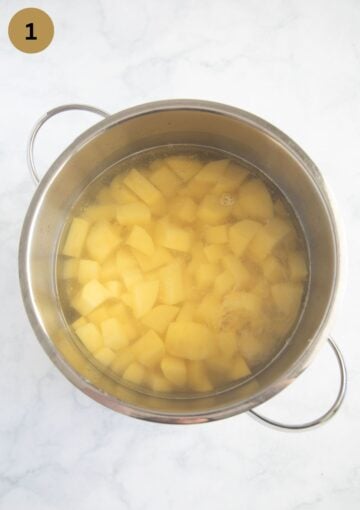 boiled potato cubes in a pot full of water for making mash.