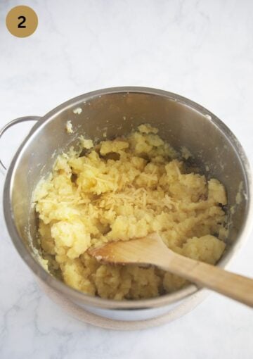mixing grated cheese into mashed potatoes.