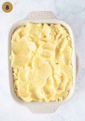 unbaked shepherd's pie with mashed potatoes in a baking dish.