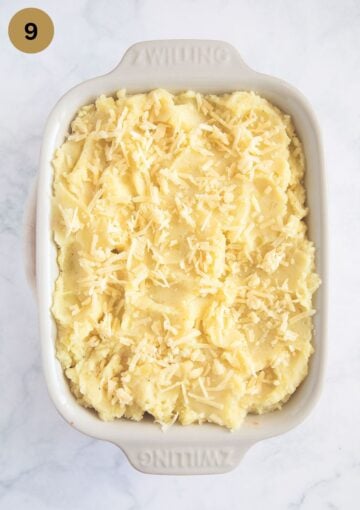 unbaked shepherd's pie with grated cheddar on top.