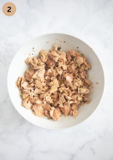 flaked, cooked salmon for making poke bowls in a large bowl.