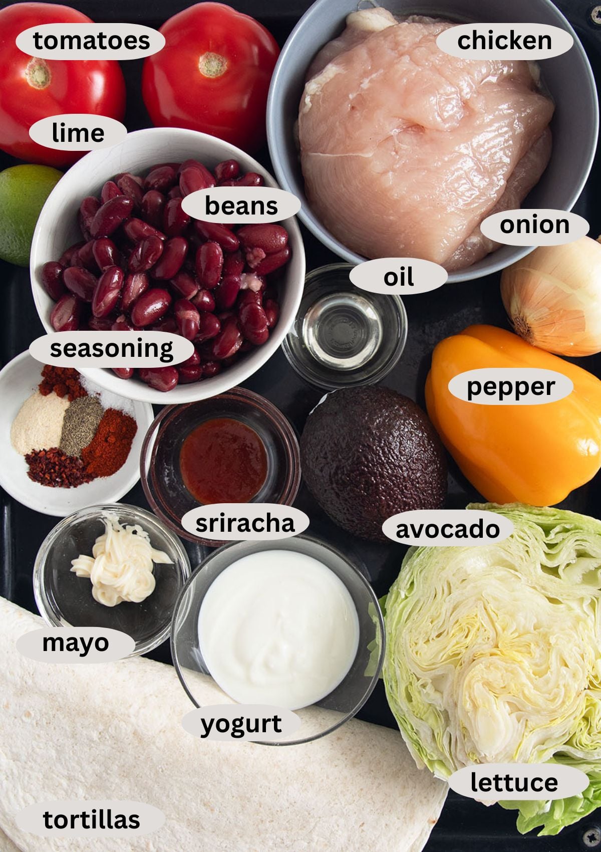 labeled ingredients for making mexican wraps with chicken, beans, avocado, lettuce, and spicy yogurt sauce.