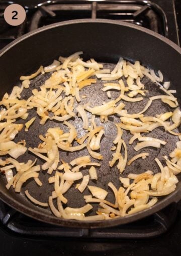 cooking sliced onions for making wrap filling in a pan.