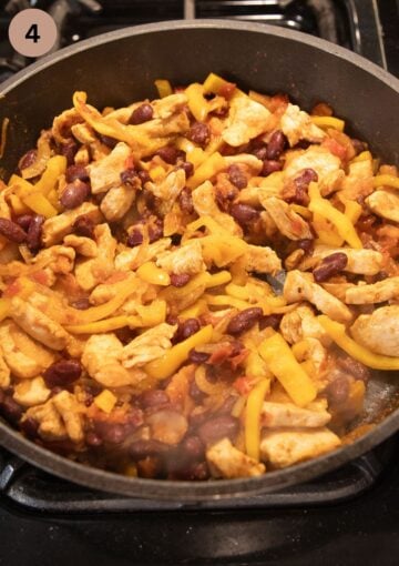 cooking chicken and bean filling for making wraps in a pan.