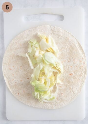 shredded lettuce on a tortilla to make wraps.