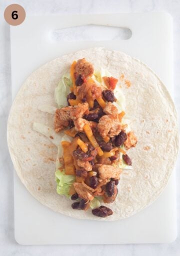 adding chicken filling to a tortilla to make wraps.