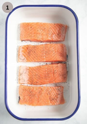 four seasoned, raw pieces of salmon in a baking dish.