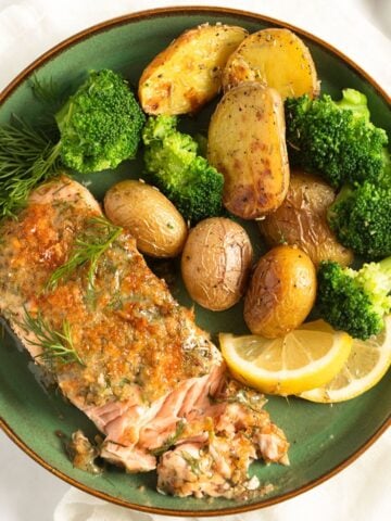 mustard dill salmon, potatoes and broccoli on a green plate.