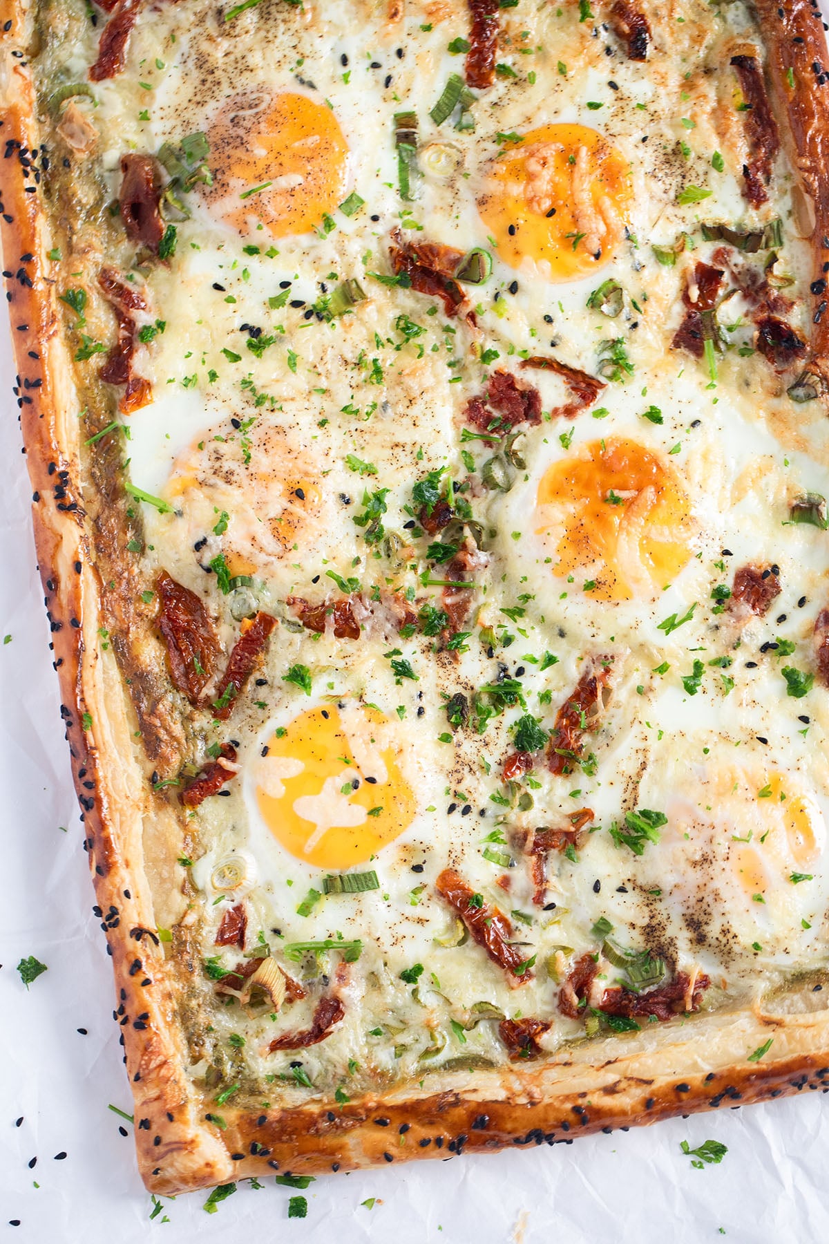 puff pastry egg tart with cheese, sprinkled with parsley.