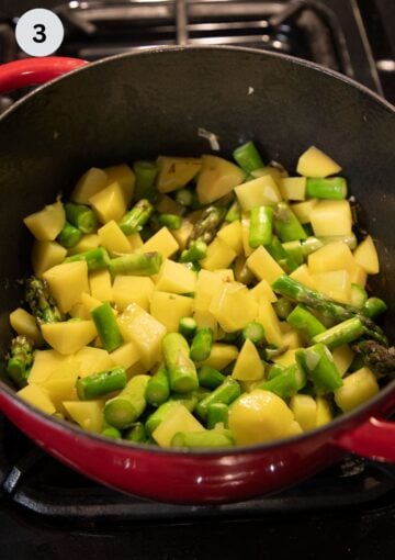 sauteing chopped potatoes asparagus and onion in a pot to make soup.