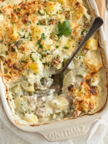 potato asparagus casserole showing the creamy filling with a spoon in it.