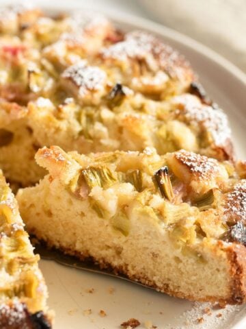 sour cream rhubarb cake sliced on a cake plate.