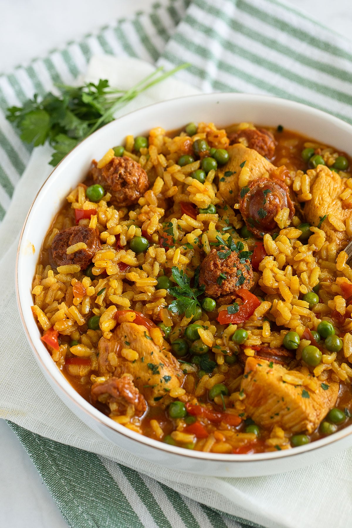chicken chorizo paella sprinkled with rice in a large bowl.