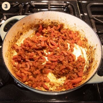 sauteing peppers with onions in a pot to make paella.