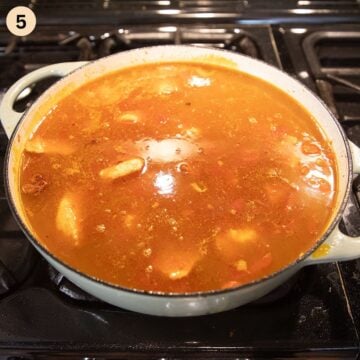 adding broth to a rice pot to make paella.